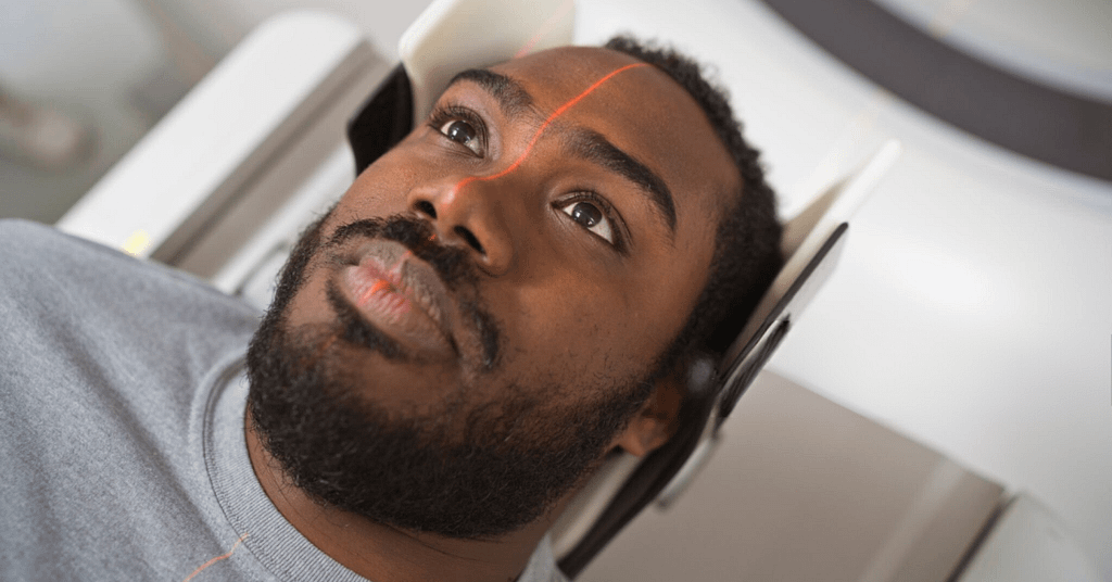 Male patient undergoing MRI scan in medical examination room. Close up of face.