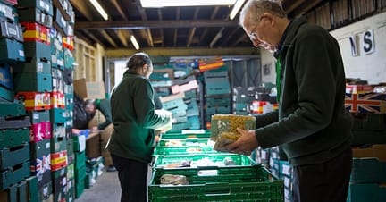 2 staff working in a food bank. 
